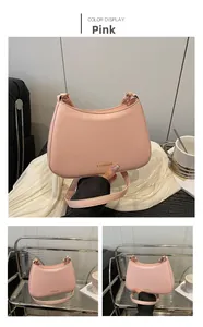 Detailaufnahme einer rosa Baguette-Tasche aus Kunstleder mit goldenem FASHION-Schriftzug
