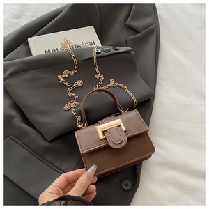 Detailed view of a brown matte leather crossbody bag with golden chain and T-shaped lock