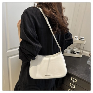Sac hobo blanc avec logo FASHION porté par un mannequin dans un décor moderne