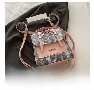 Close-up of pink bow and heart pendant on vintage grey checkered mini backpack