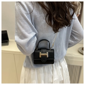 Mini borsa nera a tracolla con dettagli dorati indossata da una modella per lo stile