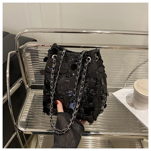 Gros plan détaillé d'un sac seau noir à paillettes avec chaîne argentée et œillets en métal