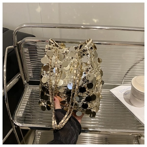 Détails du sac seau à paillettes dorées avec bandoulière chaîne et finitions brillantes