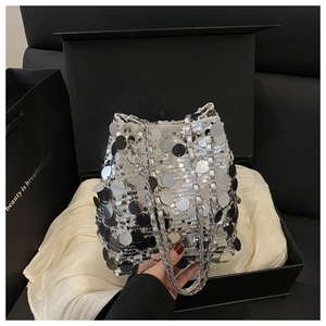 Gros plan du sac seau à paillettes argentées avec chaîne dans un coffret cadeau