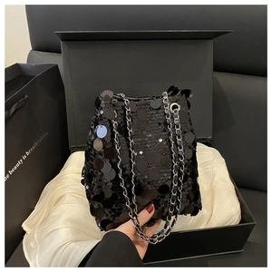 Détail du sac seau à paillettes noires avec chaînes argentées dans son coffret cadeau