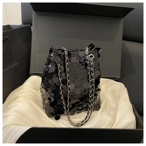 Détail du sac seau à paillettes noires avec chaîne argentée dans un coffret cadeau