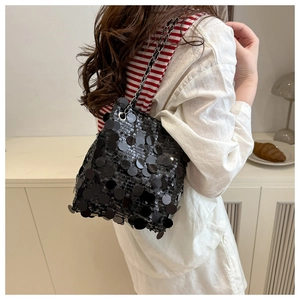 Détail de paillettes noires scintillantes et chaîne argentée sur un sac à bandoulière