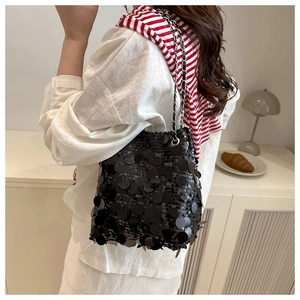 Détails des paillettes noires d'un sac seau avec bandoulière en chaîne argentée