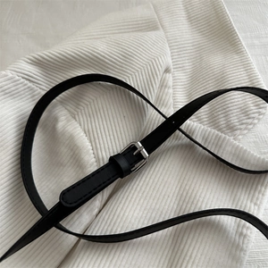 Ceinture fine en similicuir noir avec boucle argentée sur tissu en velours côtelé