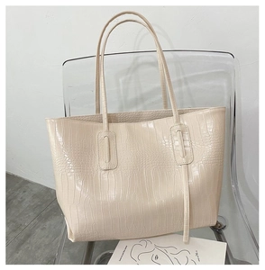 Detail of cream crocodile embossed texture on a large minimalist leather tote bag