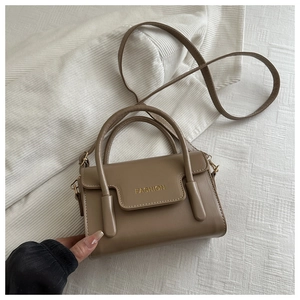 Detailed shot of khaki PU leather bag with gold FASHION letter buckle and top handle