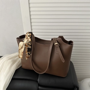 Minimalist dark brown tote bag with contrast stitching and decorative silk scarf detail