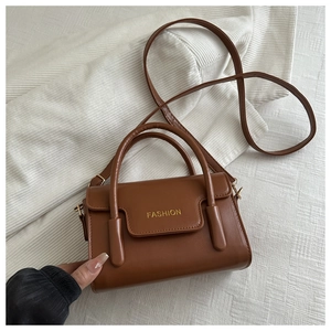 Top view of brown PU leather handbag with gold FASHION text and top handles
