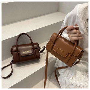 Detail view of vintage small square bags in dark brown and caramel with gold text