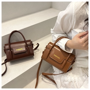 Detail view of vintage small square bags in dark brown and caramel with dual handles