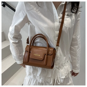 Karamellbraune Handtasche aus Leder mit goldener 'FASHION' Prägung und Schultergurt