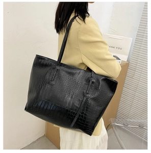 Detailed view of black crocodile pattern tote bag showing large capacity and shoulder fit