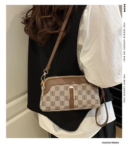 Vue latérale d'un sac bandoulière vintage avec motif monogramme et garniture en cuir