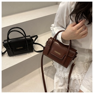 Close-up of retro crossbody bags in black and brown with gold FASHION lettering