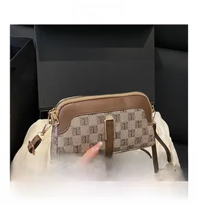 Détail de sac bandoulière vintage en toile jacquard à logo et fermeture dorée