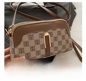 Gros plan détaillé du sac bandoulière marron à monogramme avec zip doré et finitions cuir