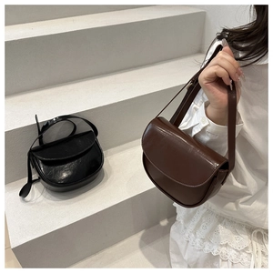 Close-up of minimalist saddle bags in polished black and brown leather on steps