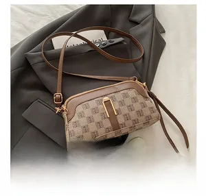Détail du sac coquille monogramme vintage avec bandoulière et dragonne sur veste