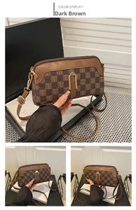 Détail du sac bandoulière marron foncé avec motif rétro et fermeture éclair dorée