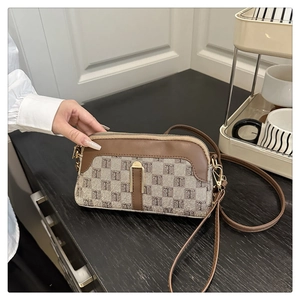 Détail de la bandoulière marron vintage avec monogramme et garnitures dorées