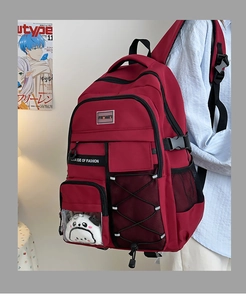 Détail du sac à dos scolaire bordeaux avec poches latérales en filet et pendentif panda