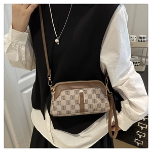 Détail du mini sac coquillage avec garniture brune, toile à motif T et boucle dorée