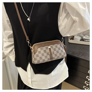 Détail du sac bandoulière avec rabat en cuir marron et texture à motif monogramme