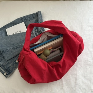 Red large-capacity nylon tote bag with wide straps shown with iPad and daily essentials