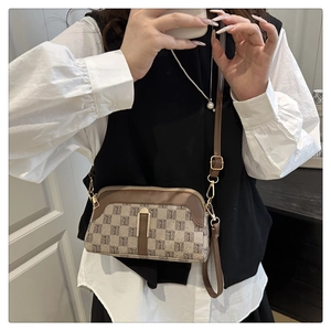 Détail du sac à bandoulière marron vintage avec motif monogramme et boucle en métal doré