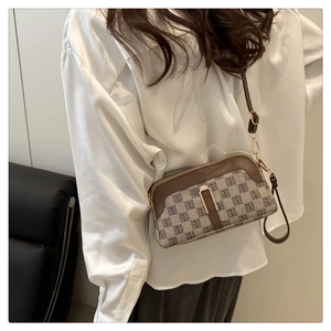 Détail d'un petit sac bandoulière en toile beige avec motifs et bordure en cuir