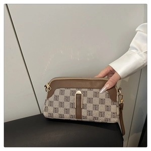 Détail du sac à main monogramme en toile avec bordures en cuir marron et fermoir doré chic