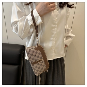 Détail du sac vintage en cuir marron et jacquard avec boucle métallique dorée en U