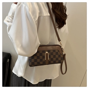 Gros plan d'un sac à main marron à carreaux avec boucle dorée et bandoulière réglable
