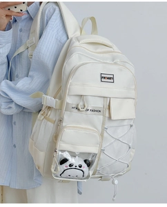 Vue latérale du sac à dos crème avec une peluche panda dans la poche transparente