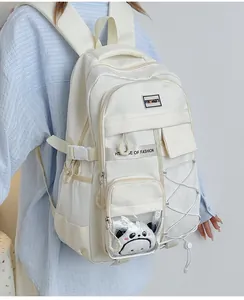 Détail du sac à dos blanc cassé avec peluche panda et compartiment transparent de mode