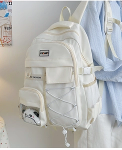 Vue latérale d'un sac à dos blanc cassé avec pendentif panda et poches multiples