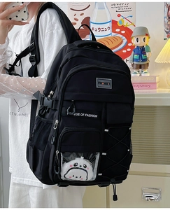 Détail du sac à dos scolaire en nylon noir avec peluche panda et fenêtre transparente