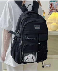 Vue latérale d'un grand sac à dos noir imperméable avec une peluche panda décorative
