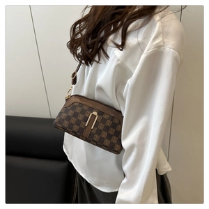Détail d'un sac bandoulière tendance avec motif à carreaux marron et détails dorés