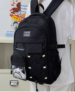 Détail d'un sac à dos scolaire noir imperméable avec pendentif panda et poche filet latérale