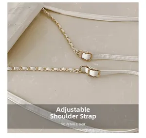Detail of white quilted texture with adjustable chain strap and gold metal buckle