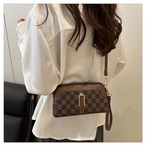 Détail du sac bandoulière marron à carreaux avec motif en T et boucle en métal doré