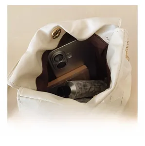 Top view of white quilted chain bag interior showing storage space for daily items