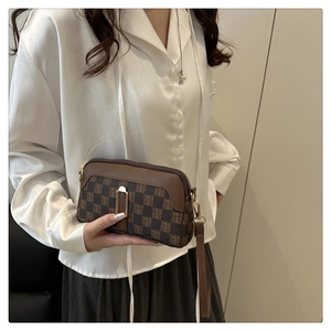 Gros plan d'un petit sac rétro à carreaux en cuir PU avec fermeture éclair métallique robuste