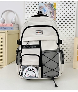 Gros plan d'un sac à dos scolaire avec une peluche panda dans une poche transparente